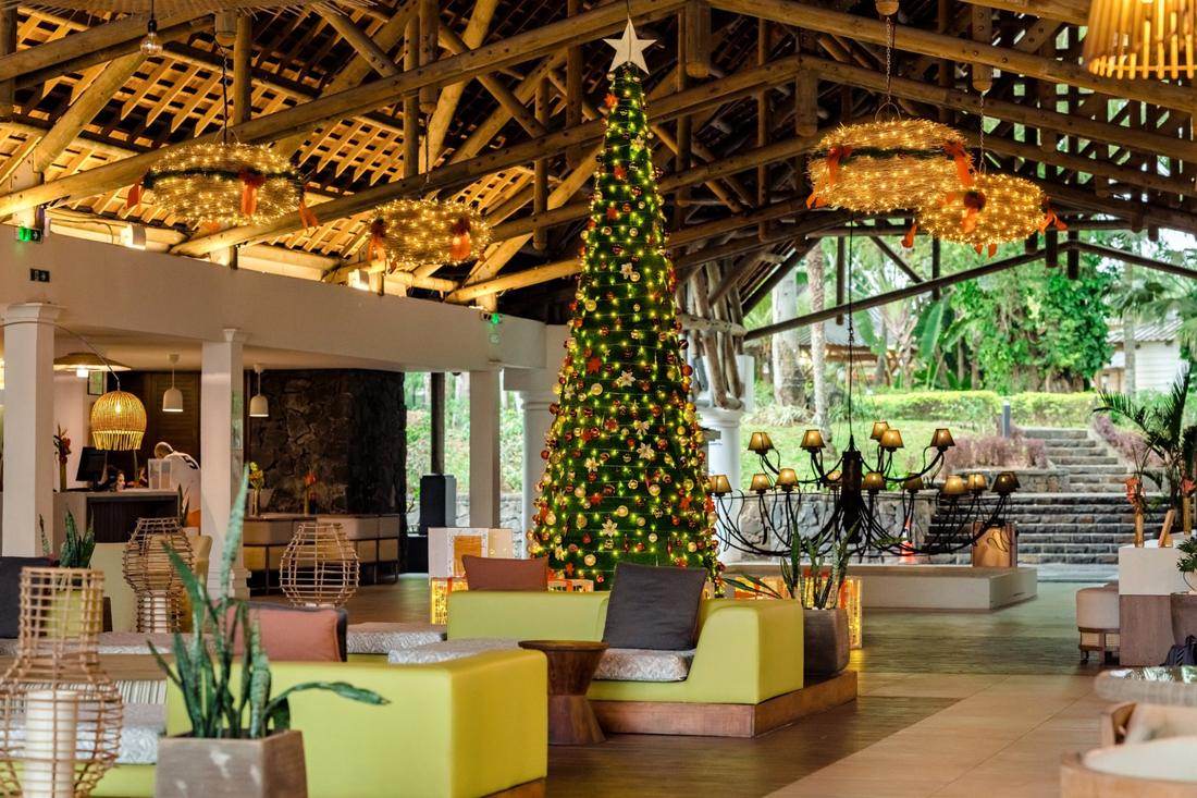 Weihnachtlich geschmückte Hotellobby mit großem, beleuchtetem Christbaum